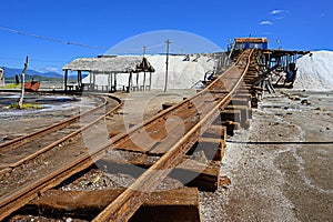 Vintage railway to salt mountain. Old rails at salt factory. Sea salt. Blue sky