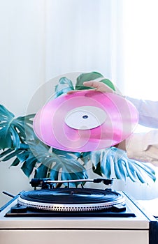 Vintage record player pink vinyl record hand tropical leaves old turntable