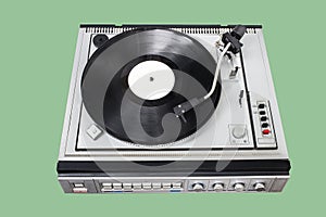 Vintage record player with radio tuner on green background