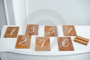 Vintage rectangular shaped wooden number buttons on a white wooden table.