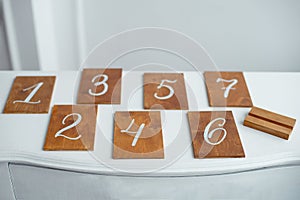 Vintage rectangular shaped wooden number buttons on a white wooden table.