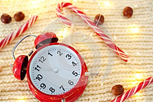 Vintage red alarm clock on white background. alarm clock shows five to midnight. Christmas sweets, garlands and alarm clock on a w