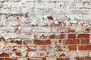Vintage red brick wall on the building with white plaster peeling off from time