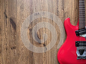 Vintage Red Electric guitar made from mahogany wood With a black and white pickguard, old brown wood background with copy space