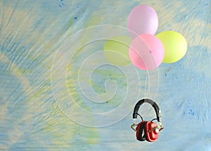 Vintage red headphone and balloons floating on batik fabric background, podcasting,music, inspriation concept. Free copy space photo