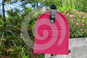Vintage red mail box at home garden by green tree
