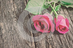 Vintage red rose flowers with on old wooden table