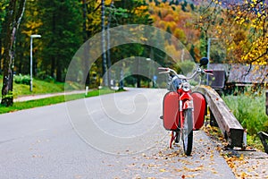 Vintage red scooter motor bike near Bohinj Lake, Slovenia. Colorful autumnal scene.