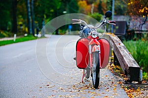Vintage red scooter motor bike near Bohinj Lake, Slovenia. Colorful autumnal scene.