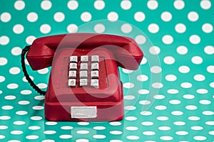 Vintage Red Telephone on Green Background with White Polka Dots