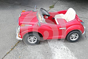 Vintage red toy car for children and kid in the street, toy car parked on road