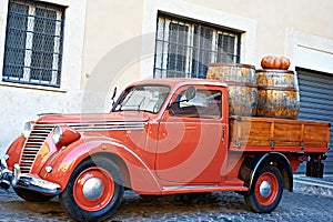 Vintage red van with old wooden barrels of wine