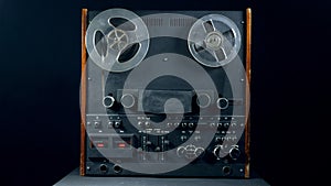 Vintage reel player with spinning bobbins.