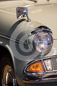 Vintage restored classic car close-up. Sealed-beam retro headlamp. Sixties headlight.