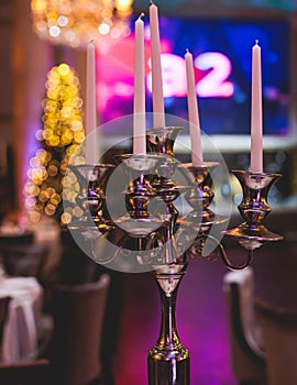 Vintage retro brass candlesticks with candles burning, luxury event banquet table setting decoration in a restaurant hall,