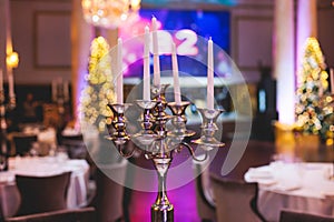 Vintage retro brass candlesticks with candles burning, luxury event banquet table setting decoration in a restaurant hall,