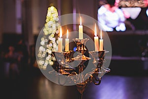 Vintage retro brass candlesticks with candles burning, luxury event banquet table setting decoration in a restaurant hall,