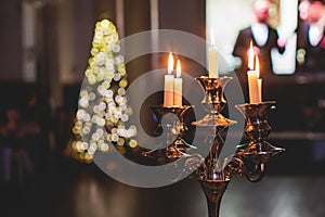 Vintage retro brass candlesticks with candles burning, luxury event banquet table setting decoration in a restaurant hall,