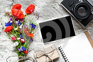 Vintage retro camera with blank photo frame and wildflowers bouquet with lined notebook and gift box