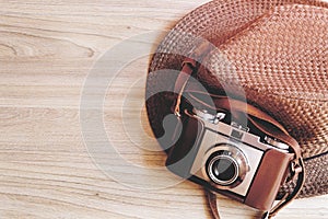 Vintage or Retro camera with brown hat on wooden background, retro effect style