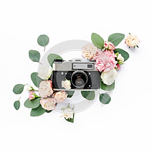 Vintage retro camera, decor of pink and beige rose flower buds pattern on white background. Flat lay, top view