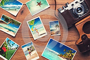 Vintage retro camera with travel photos on wooden background