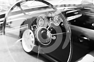 Vintage retro car interior, steering wheel, dashboard, black and photo