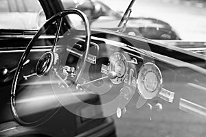 Vintage retro car interior, steering wheel, dashboard, black and photo