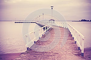 Vintage retro filtered wooden pier at sunset