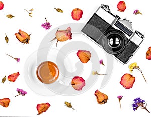 Vintage retro photo camera, dried roses and coffee cup isolated on white background. Flat lay