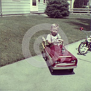 Antico giovane ragazzo giocare pedale auto 