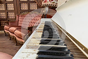 Vintage retro room setting with sofa, accessories, old rusty white piano. Ideal for postcard