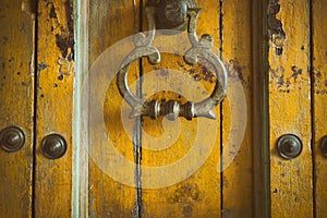 vintage retro style yellow wood door. old brass doorknob. abstract background