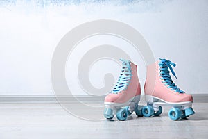 Vintage roller skates on floor near color wall.