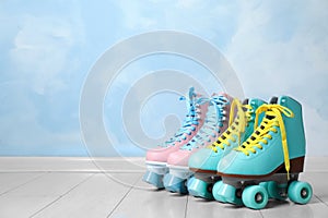 Vintage roller skates on floor near color wall.