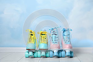 Vintage roller skates on floor near color wall.