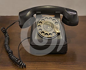 A vintage rotary dial telephone on an old wooden table