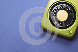 Vintage rotary phone. classic green telephone with round dial. isolated on blue background. old communication technology