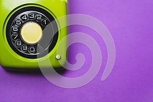 Vintage rotary phone. classic green telephone with round dial. isolated on purple background. old communication technology