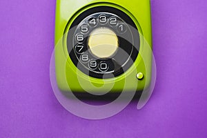 Vintage rotary phone. classic green telephone with round dial. isolated on purple background. old communication technology