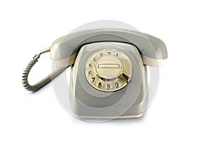 Vintage rotary phone, gray yellowed plastic on a white backgrou