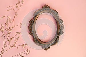 Vintage round bronze photo frame and dried twigs on pink background. Picture frame mockup.