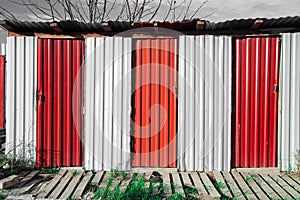 Vintage rural rustic construction tin red and white color country side toilet simple ugly architecture object frame outskirts