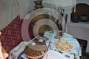 Vintage Russian samovar and bread salt on the table covered with a tablecloth.Welcome to Russia. From Russia with love.