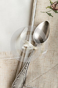 Vintage russian silverspoon with silk ribbon on linen napkin. Old fashion heroloom