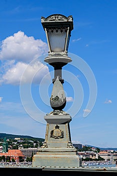 Vintage rusted lighting pole with clear blue sky in the background on SzÃÂ©chenyi Chain Bridge over Danube in Budapest, Hungary