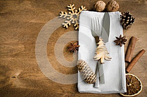 Vintage or rustic christmas table setting from above. Cutlery on napkin on rustic wooden background - country style.