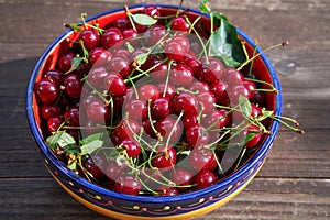 Vintage rustic colorful bowl full of fresh red riped sour cherries