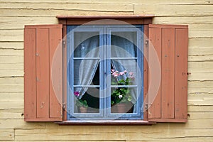 Vintage rustic window with geranium flowers on the windowsill indoors