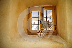 Vintage rustic window in an old thick wall, with a vase of lavan